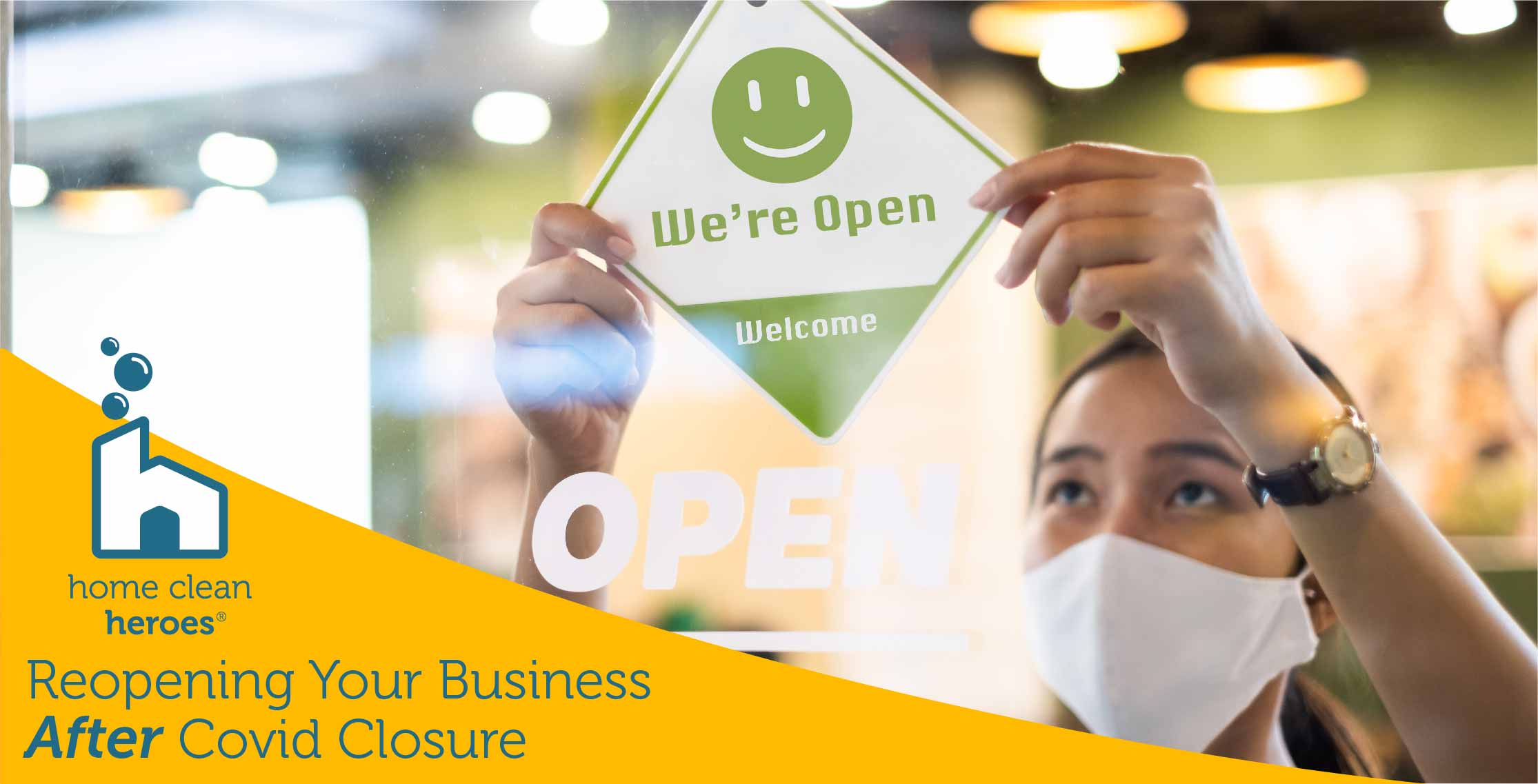  Woman wearing mask and hanging Now Open sign on front door of business